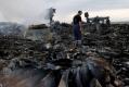 Emergencies Ministry members walk at the site of a Malaysia Airlines Boeing 777 plane crash in the settlement of Grabovo in the