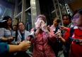 A woman, who said her name was Noraini and that she believed a relative of hers was on Malaysia Airlines flight MH-17, cries as