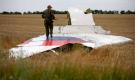An armed pro-Russian separatist stands on part of the wreckage of the Malaysia Airlines Boeing 777 plane after it crashed near 